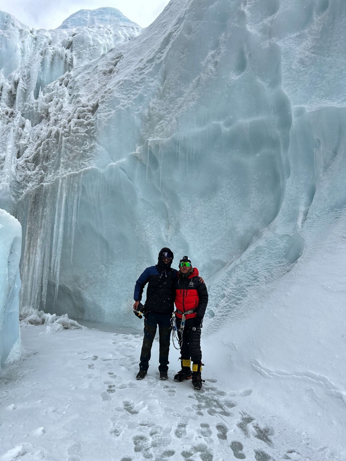 Two climbers beside a high-altitude ice wall